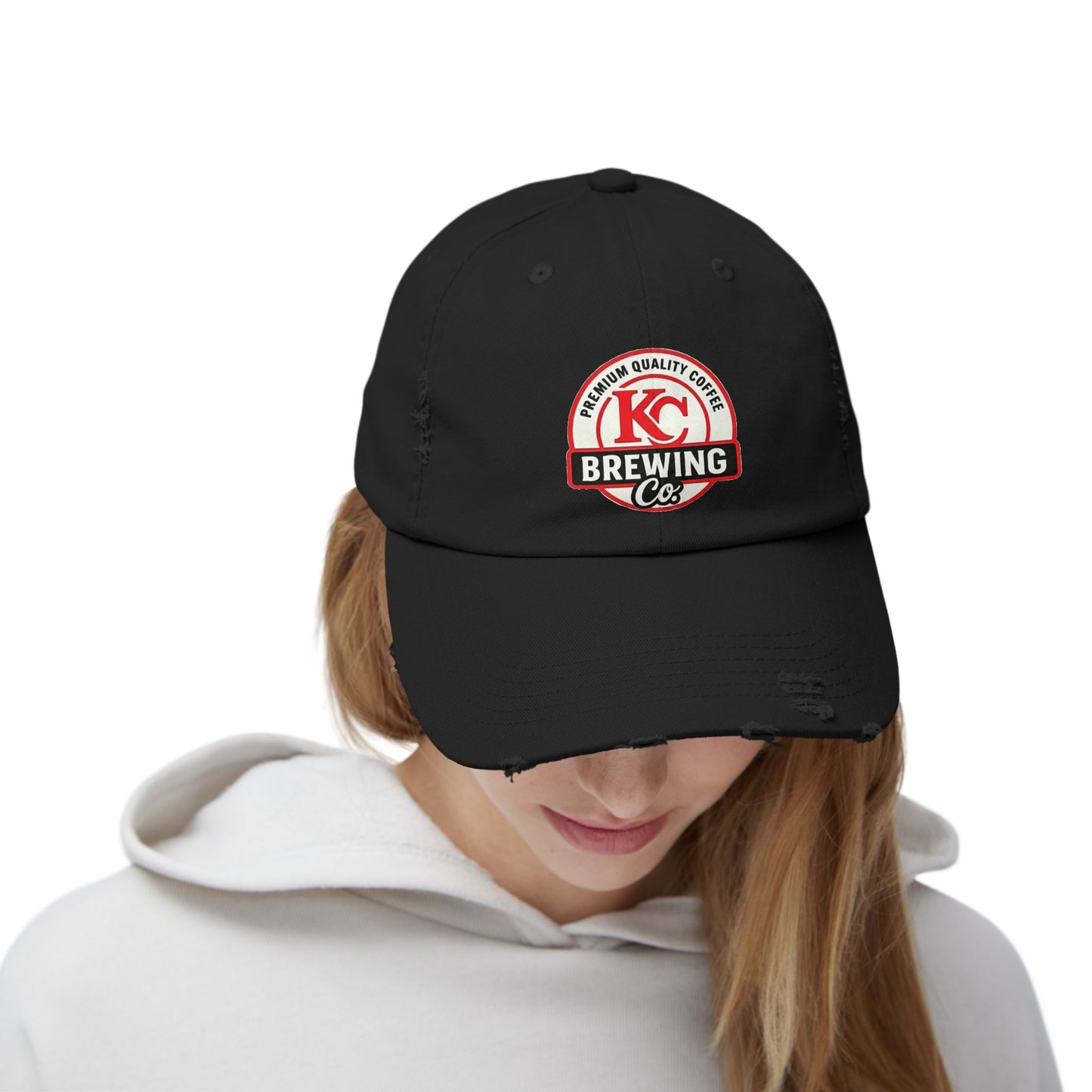 Person wearing a black cap with KC Brewing Co logo on a white background