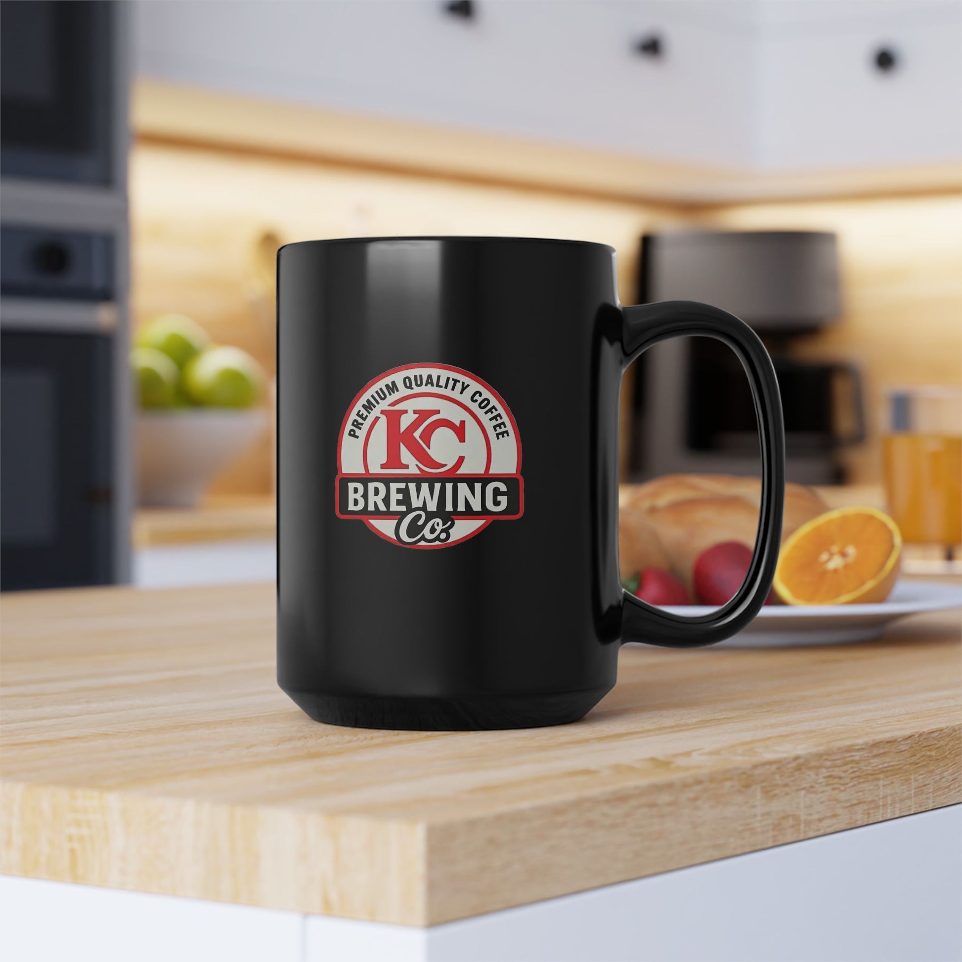 Black KC Brewing Co coffee mug on kitchen counter with breakfast plate and blurred coffee maker in background