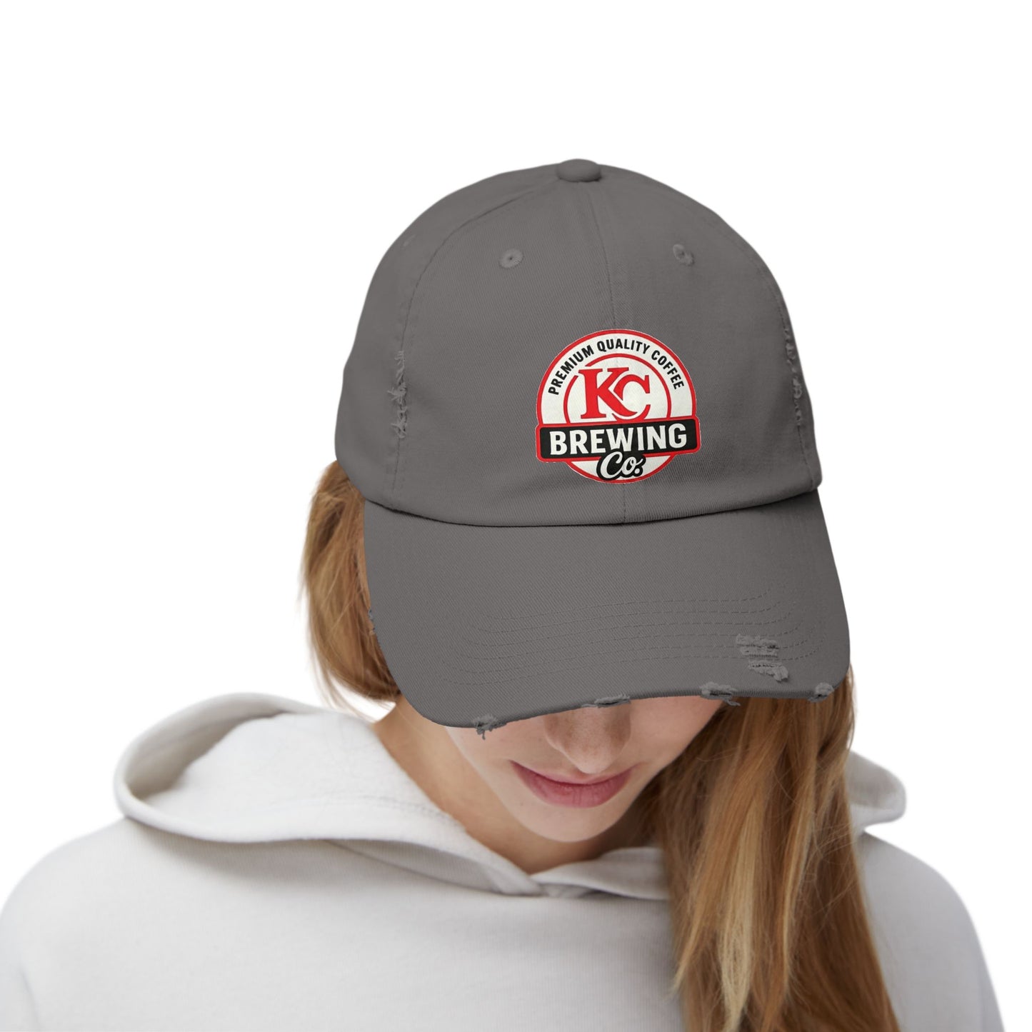 Person wearing a gray cap with KC Brewing Co logo on a white background
