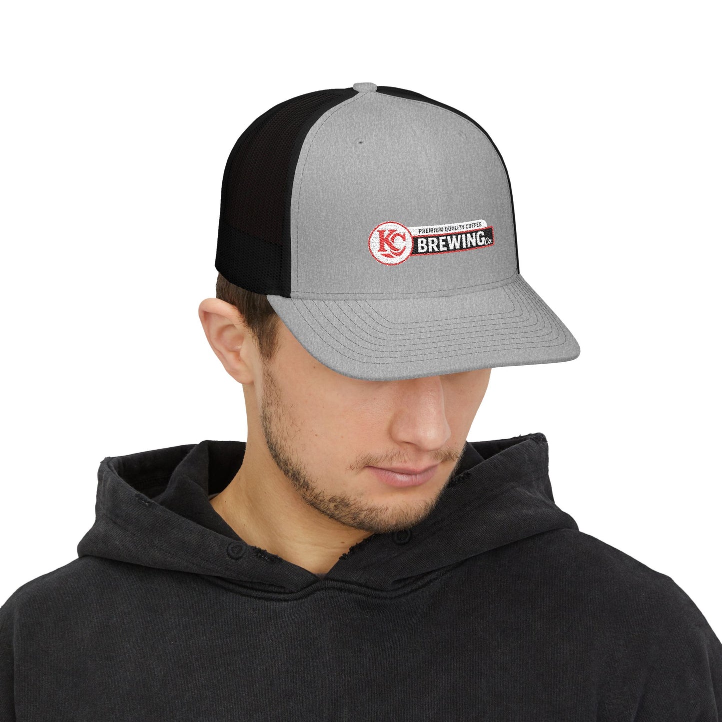 Person wearing a black and gray cap with a logo on a white background