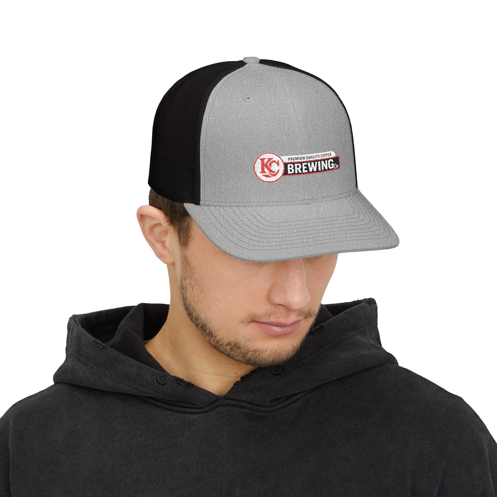 Person wearing a black and gray cap with a logo on a white background