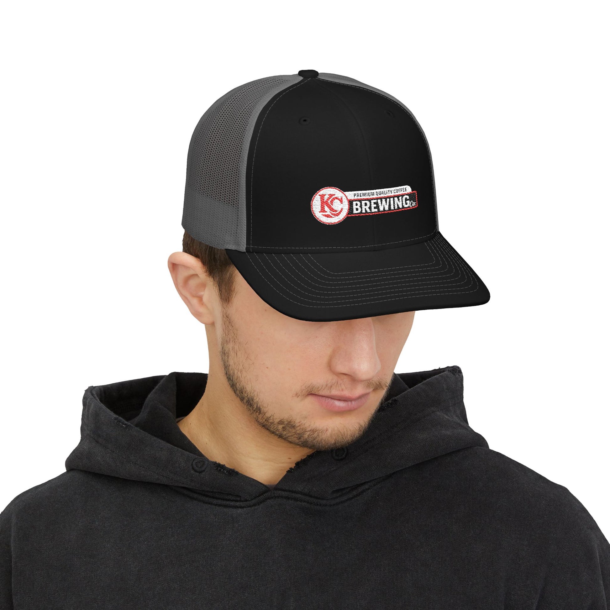 Person wearing a black and gray cap with a logo on a white background