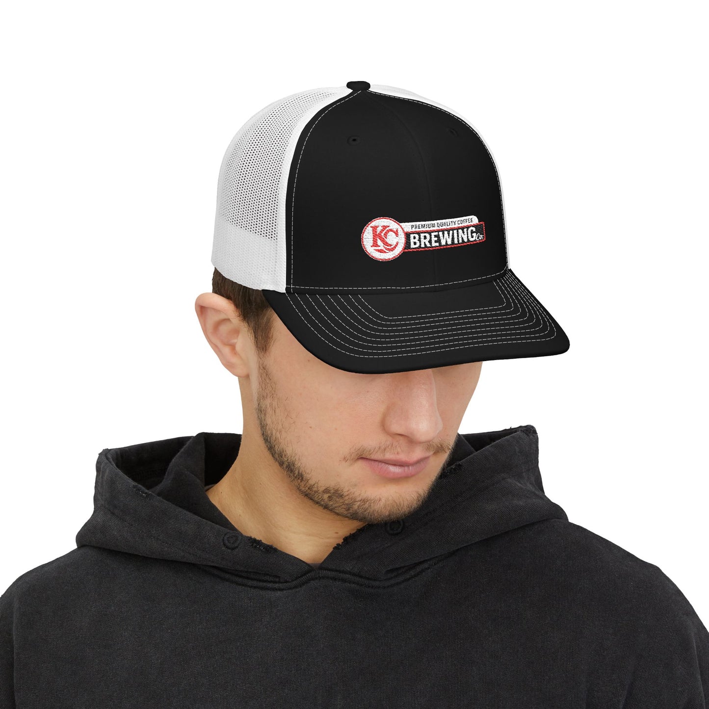 Person wearing a black and white cap with a logo on a white background