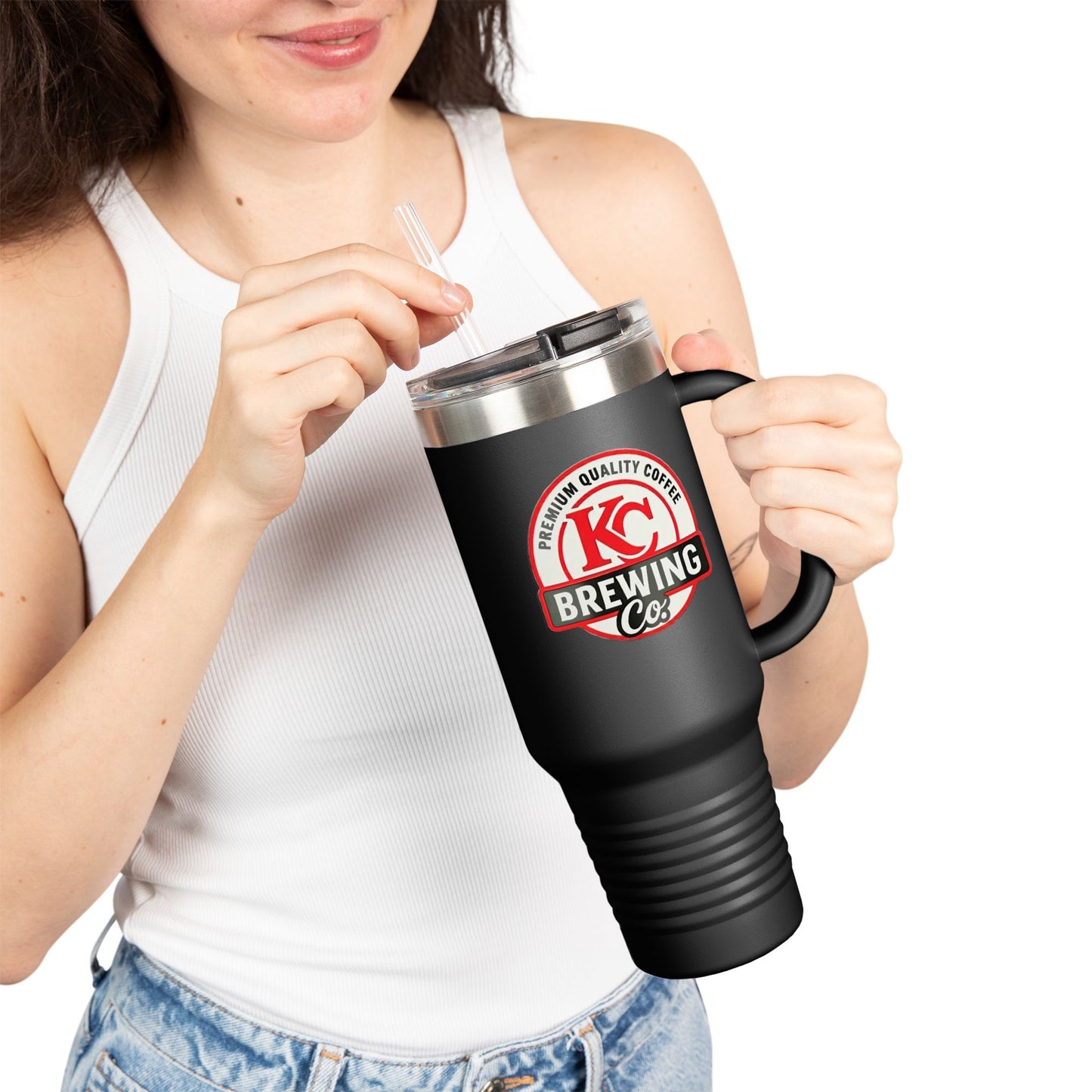 Woman in white tank top holding black KC Brewing Co insulated coffee mug with lid and straw